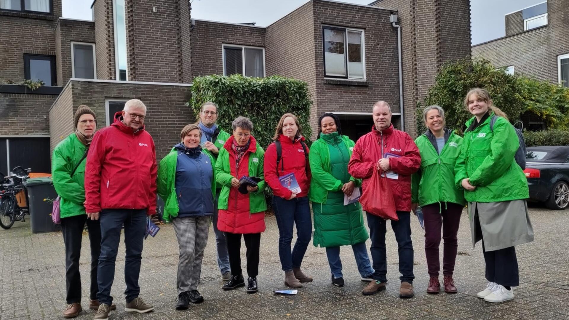 Een groep vrijwilligers van PvdA en GroenLinks met rode en groene jasjes aan