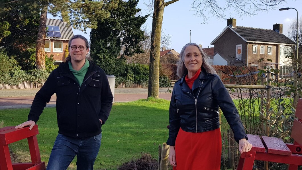 Anja en Eildert lachen naar de camera. Eildert heeft een zwarte trui aan, Anja een rode jurk met een zwart jasje eroverheen.