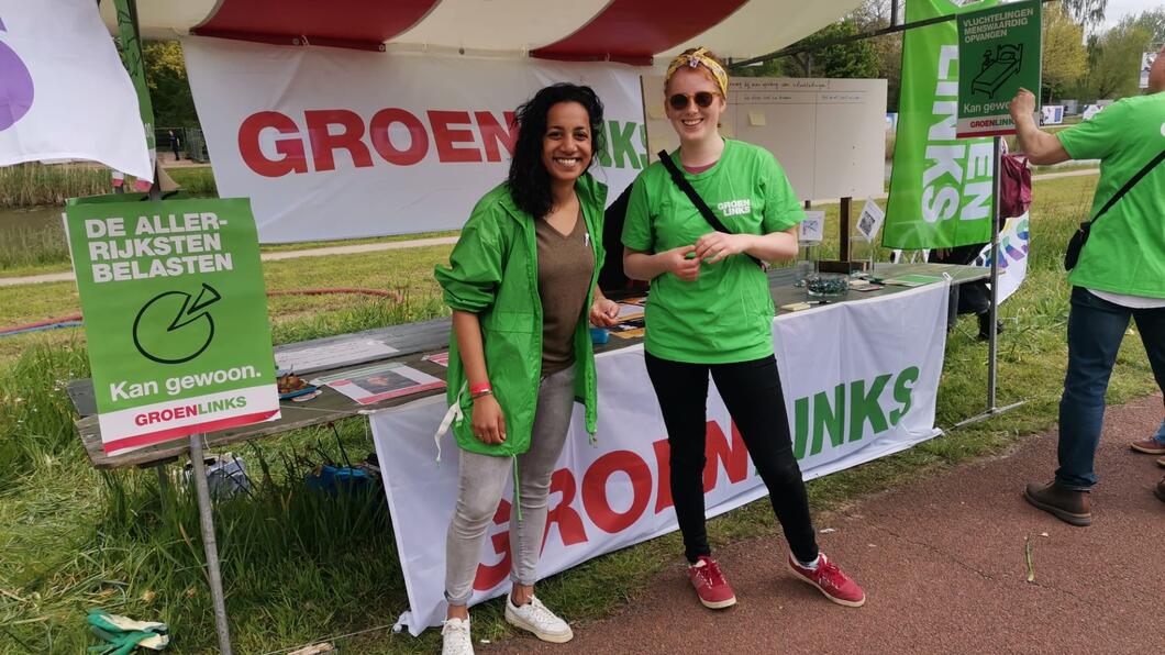 Twee vrijwilligers bij de stand van GroenLinks op het bevrijdingsfestival