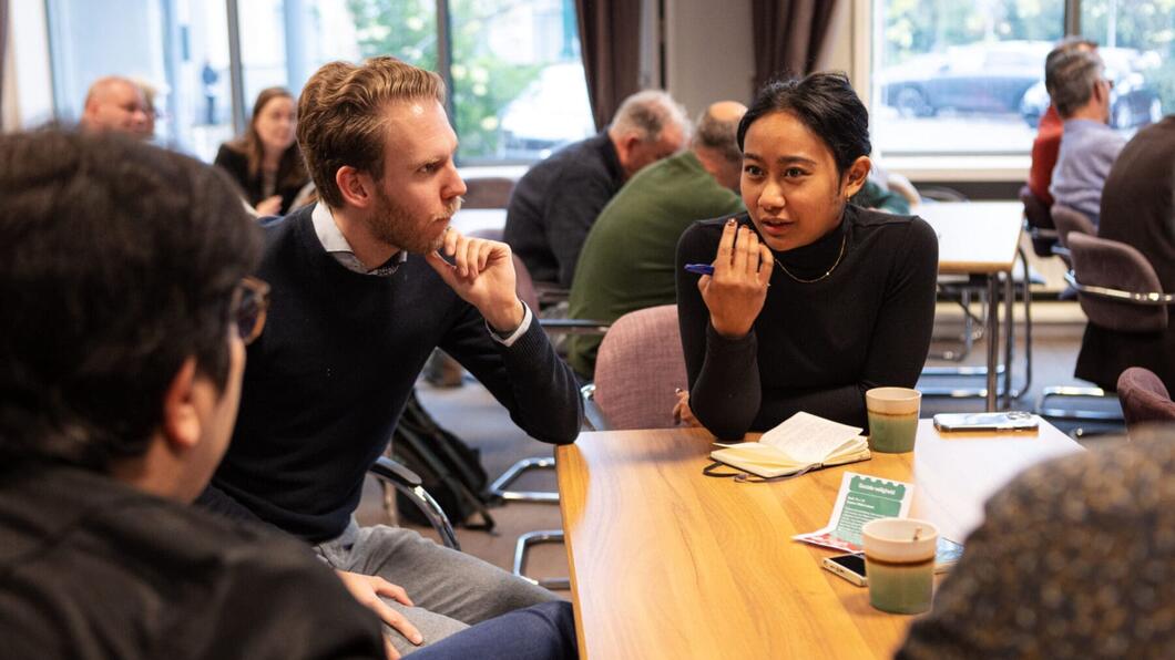 Mensen zitten rond een tafel te praten