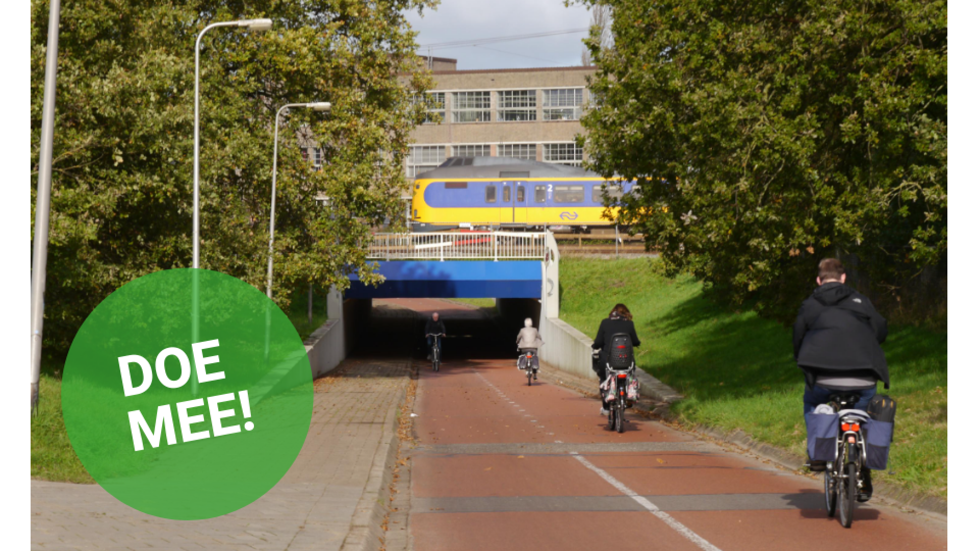 Fietsers rijden een tunnel in, bovenlangs komt een trein voorbij.