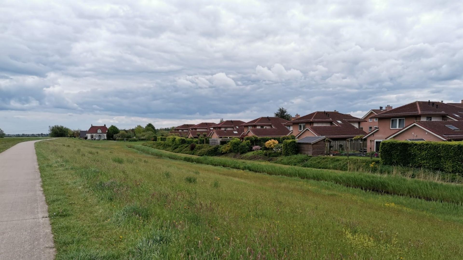 Een rij huizen gezien vanaf de dijk bij Berkum