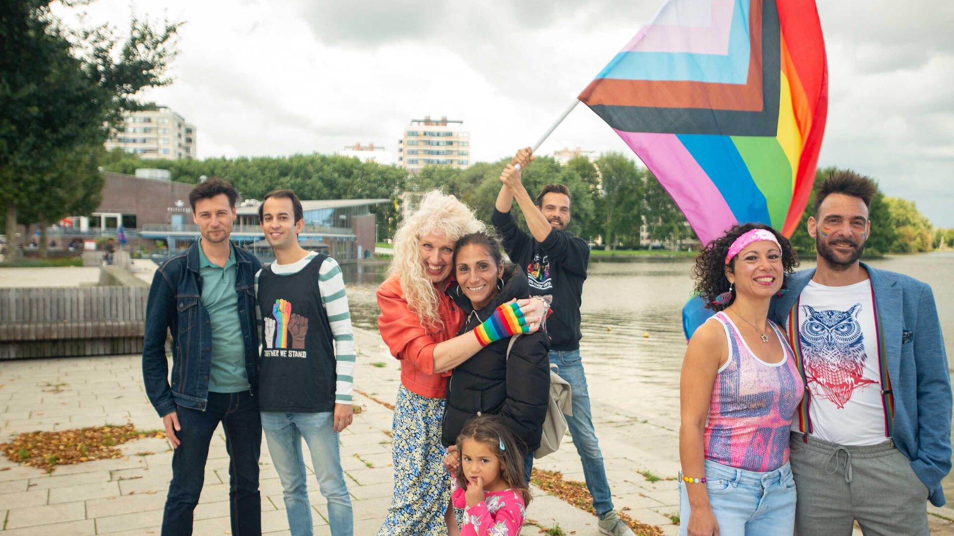 Een groep mensen met een regenboogvlag en regenboogattributen