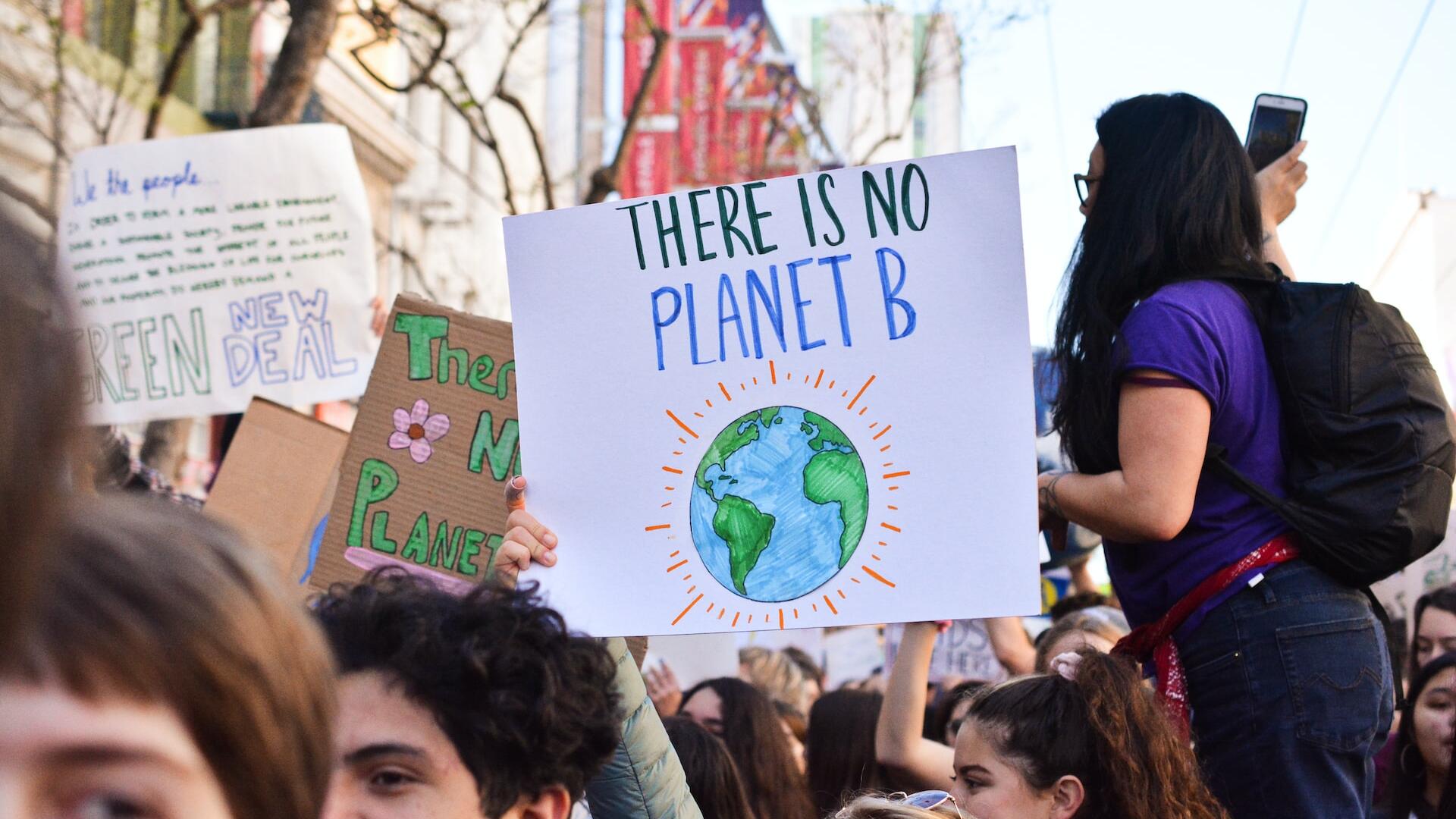 Demonstranten bij een klimaatactie. Iemand houdt een bord vast waarop staat: 'There is no planet B'