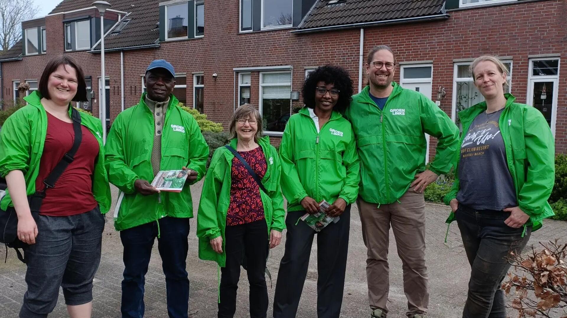 Zes vrijwilligers van GroenLinks in een straat in een woonwijk