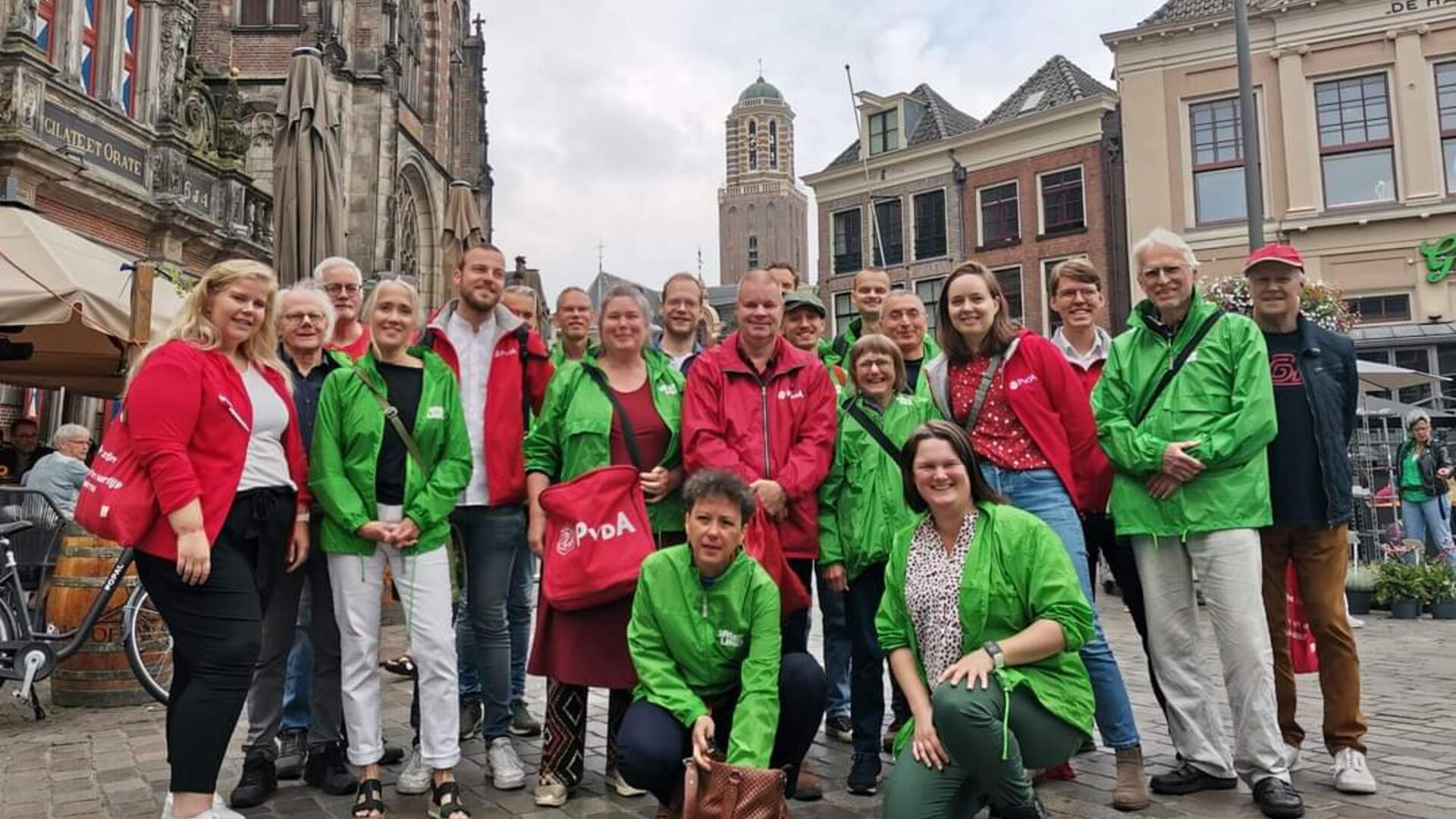 Een groep vrijwilligers van GroenLinks en PvdA met rode en groene jasjes