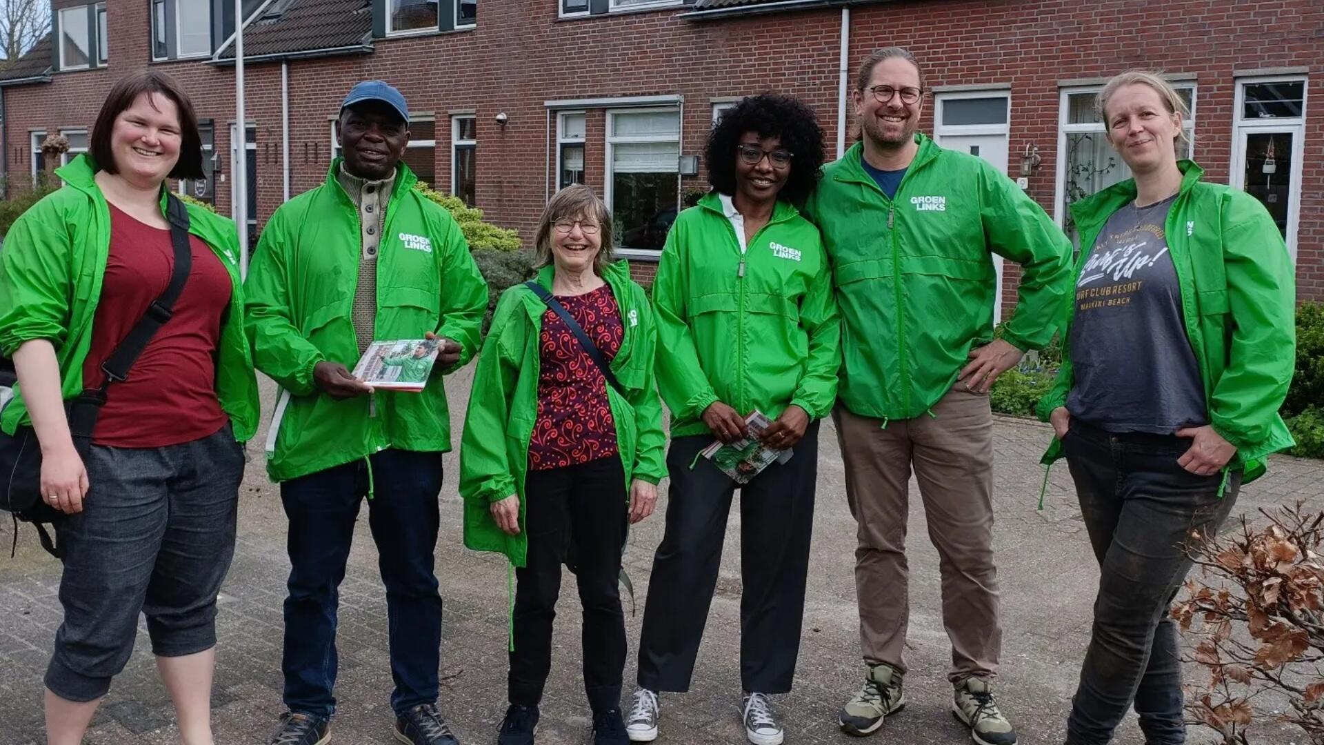 Een groep GroenLinks-vrijwilligers met groene jasjes aan